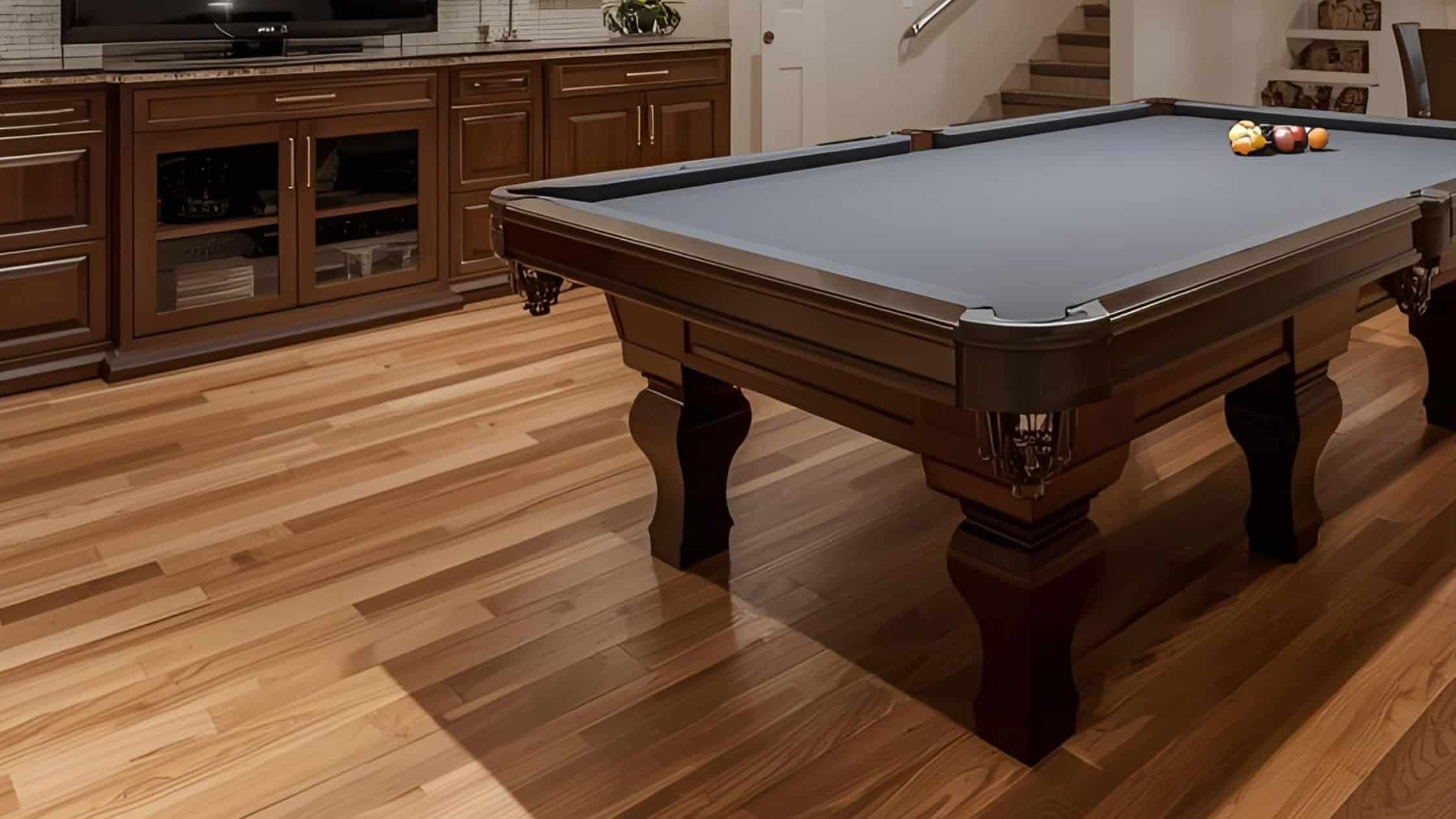 Stylish home game room with a classic pool table and hardwood flooring.