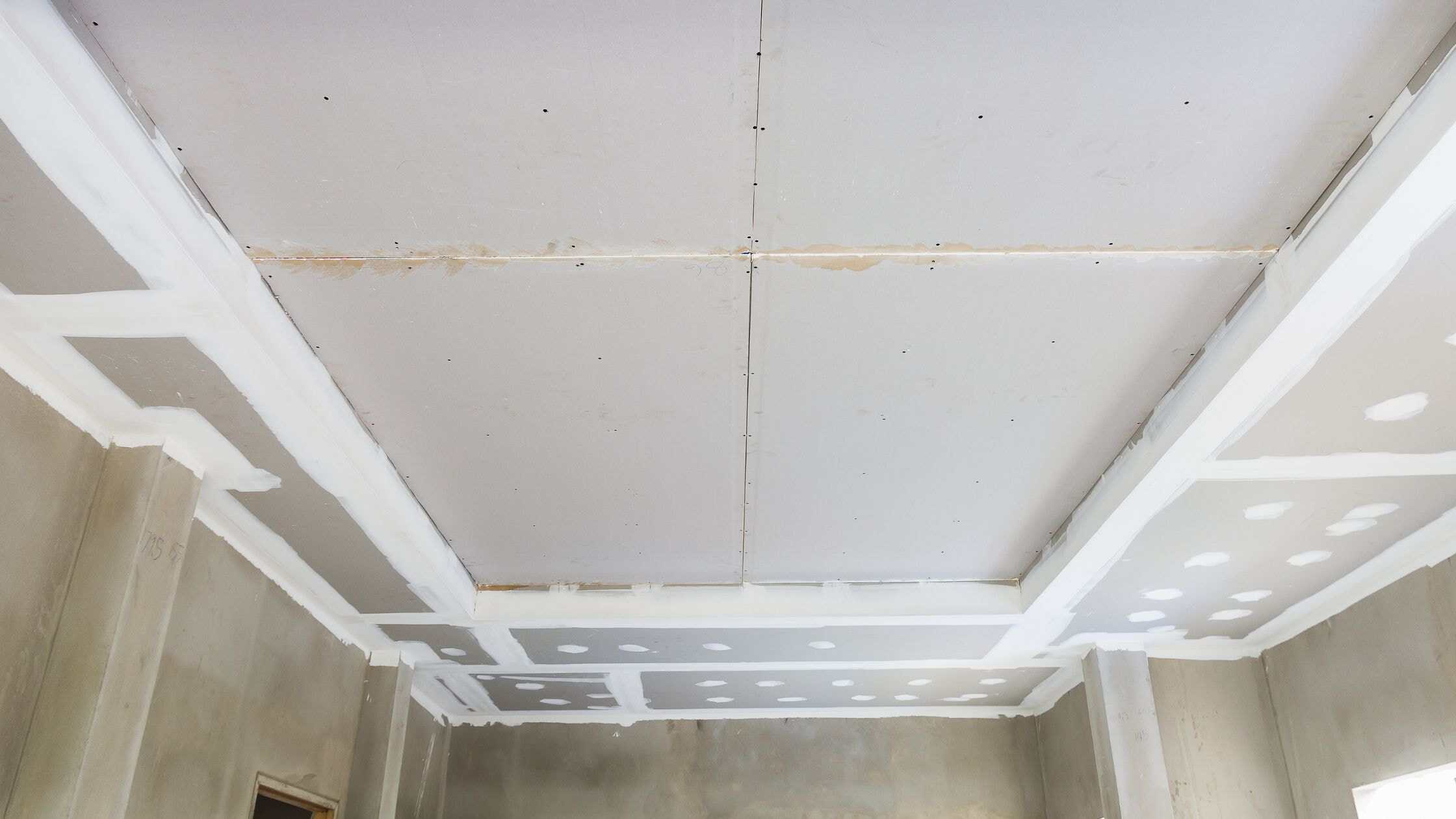 Interior ceiling renovation with drywall installation and finishing in progress.