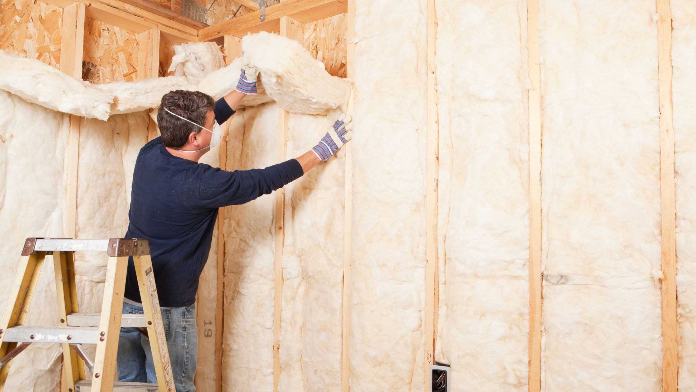 Insulation being installed in a wall for home energy efficiency.