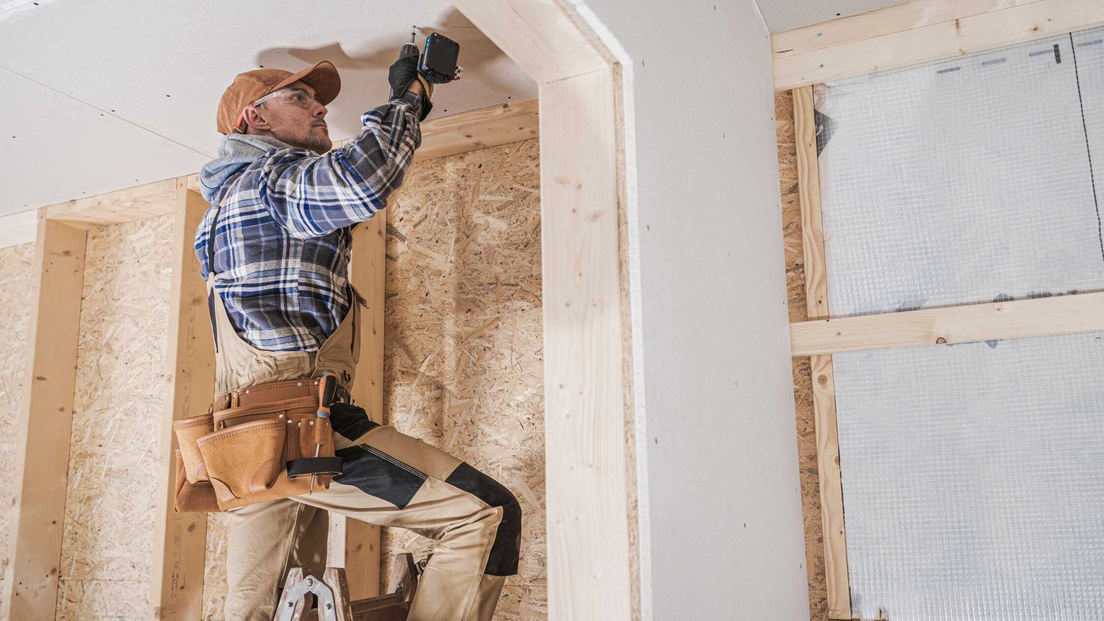 Skilled carpenter installing drywall in a home renovation project.