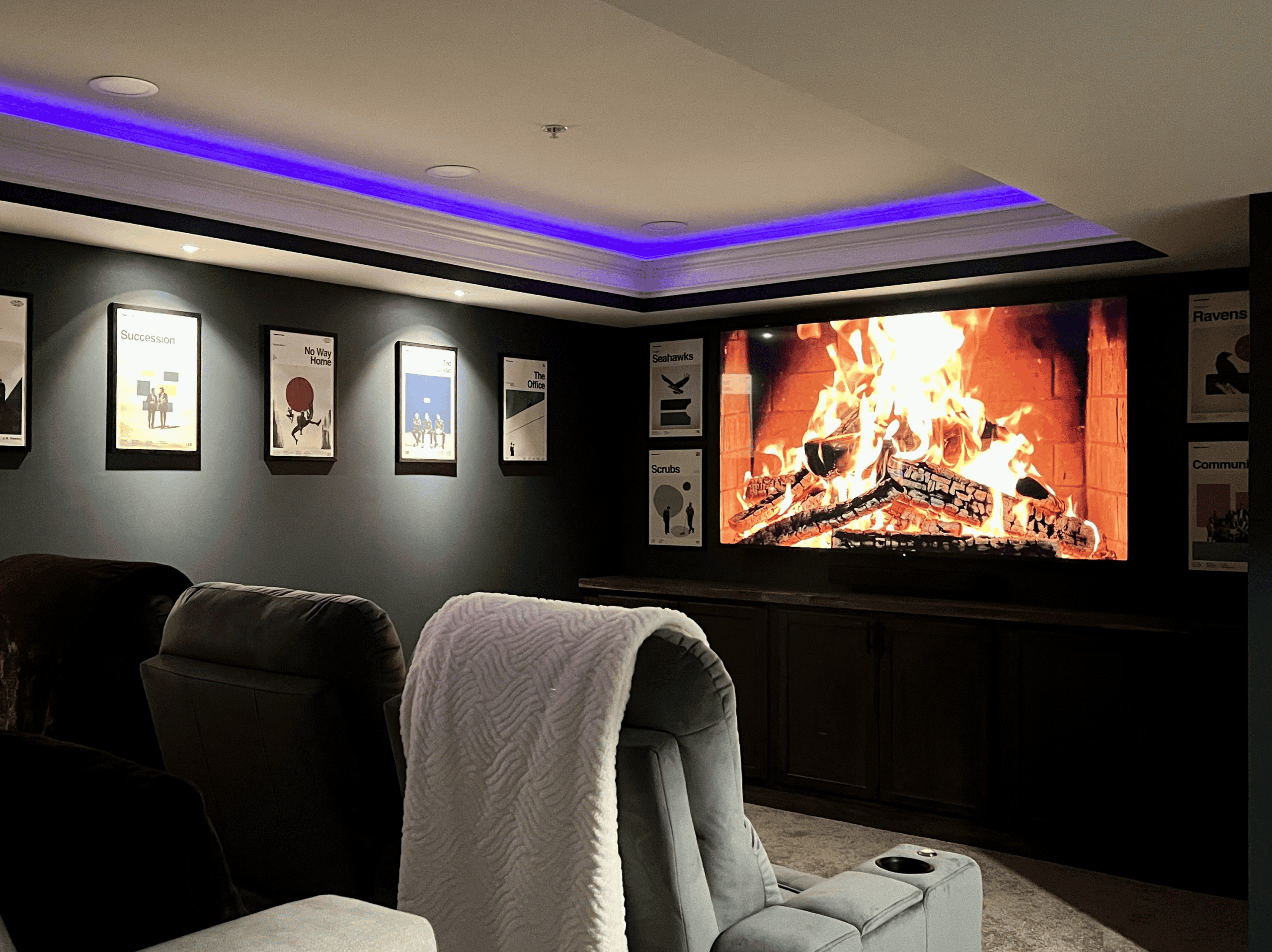 Modern home theater with a large screen, cozy seating, and ambient lighting for an immersive enterta.