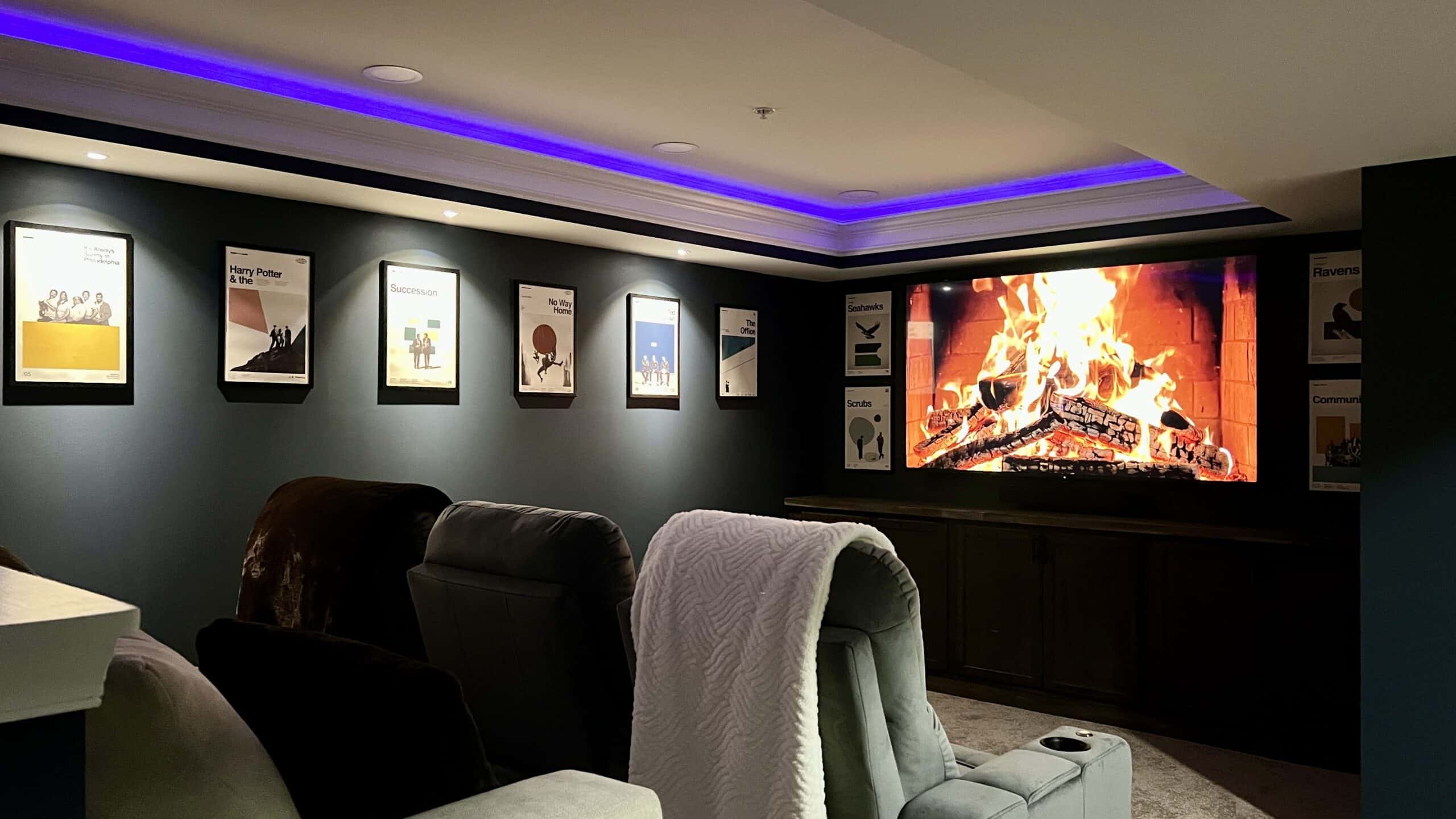 Cozy home theater with fireplace and framed artwork for a warm, inviting atmosphere.