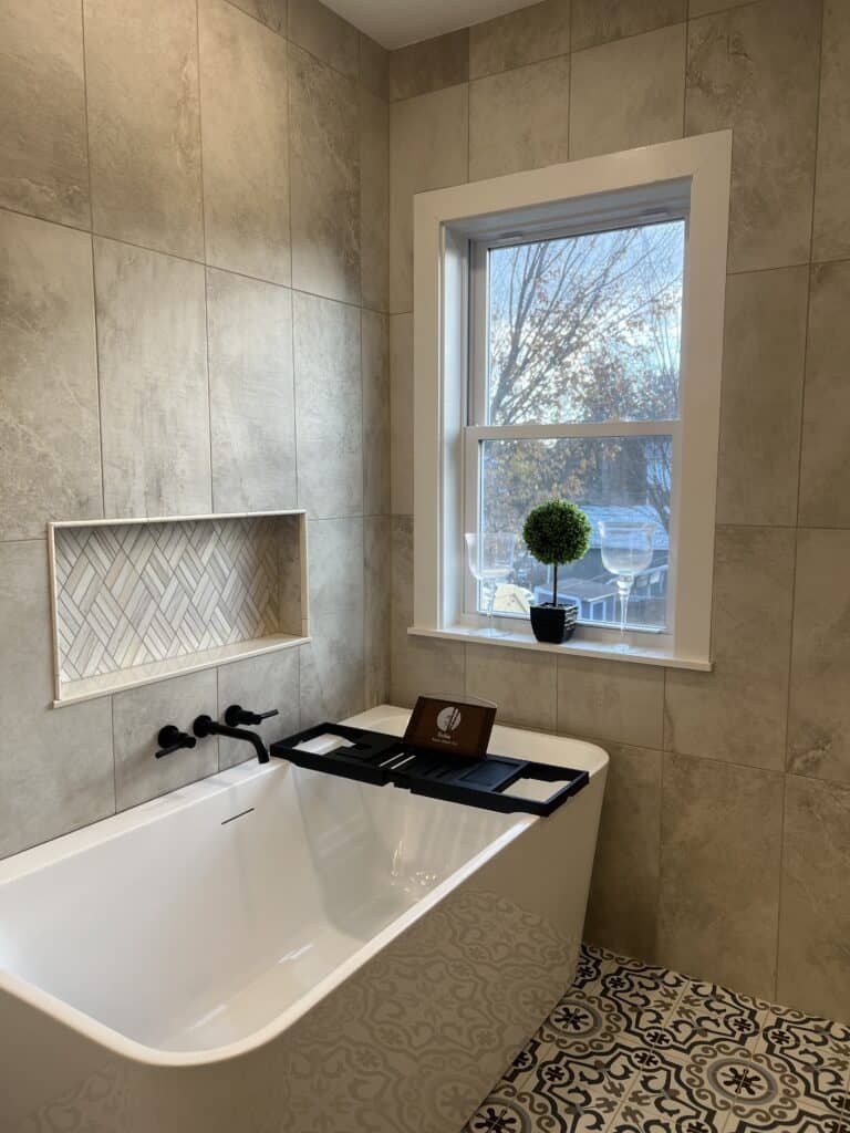 Bathroom with bathtub, window, and decorative tile wall. Bright, cozy space perfect for relaxation.