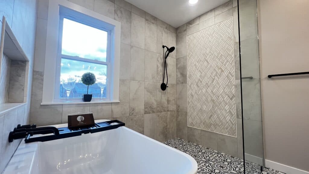 Bright bathroom with a large window, walk-in shower, and stylish tile accents.
