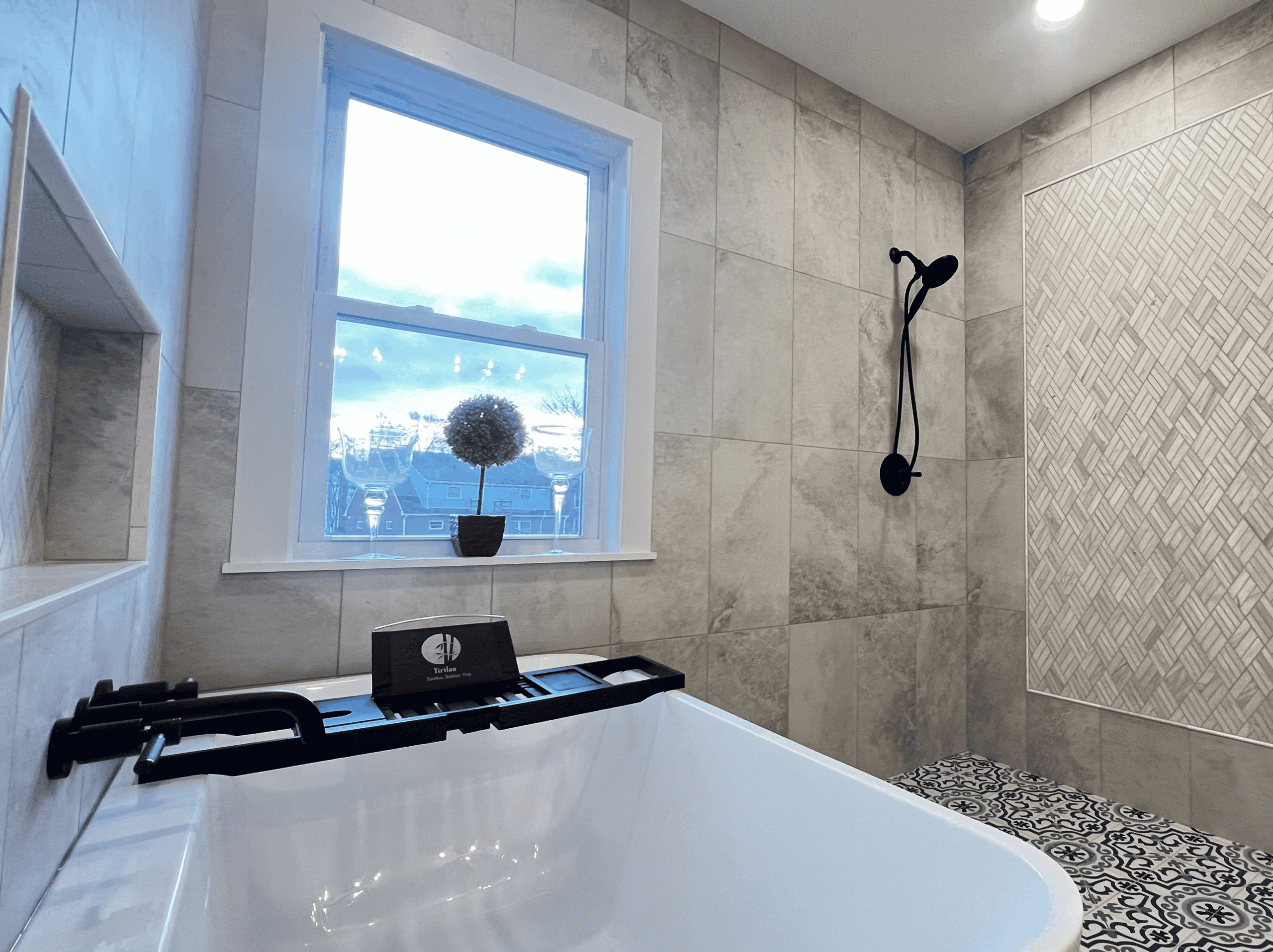 Bathroom with bathtub, window, and showerhead.