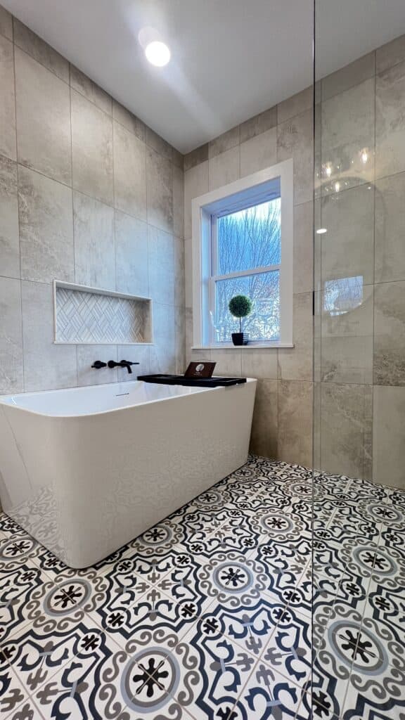 Elegant bathroom with a freestanding bathtub, patterned floor tiles, and a large window for natural.