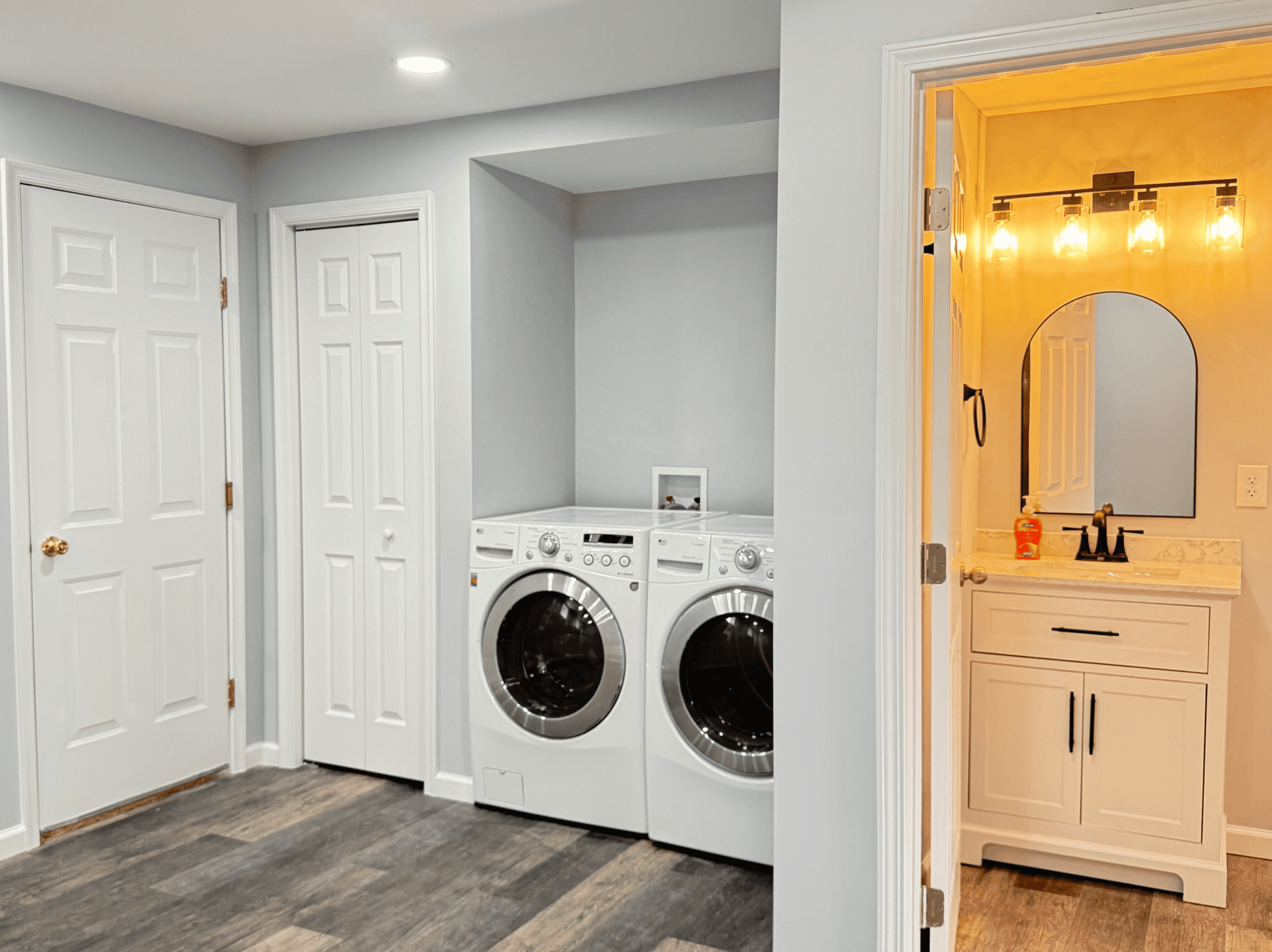 Bright laundry room with washer, dryer, and storage space in a home renovation.