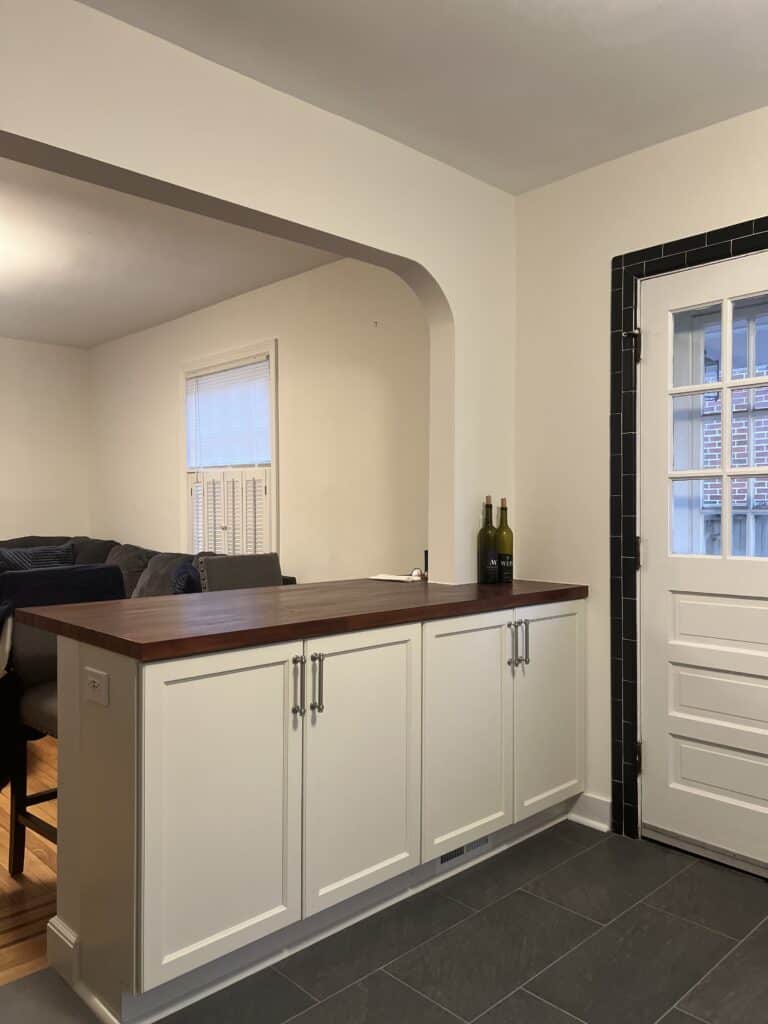 Bright and functional kitchen with white cabinets and dark wood countertop. Perfect for home improve.