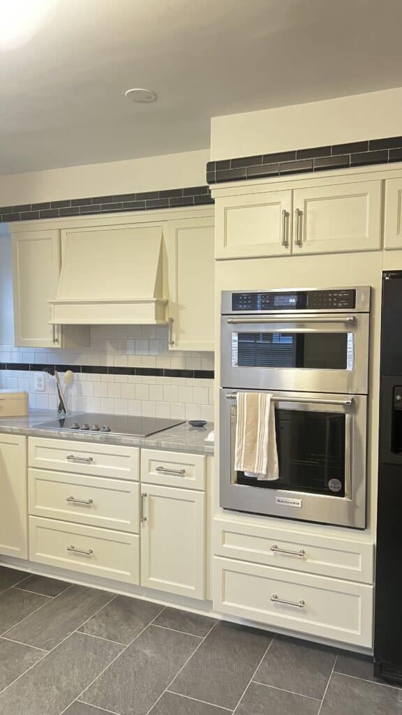 Bright white kitchen cabinets with stainless steel appliances and black accents.