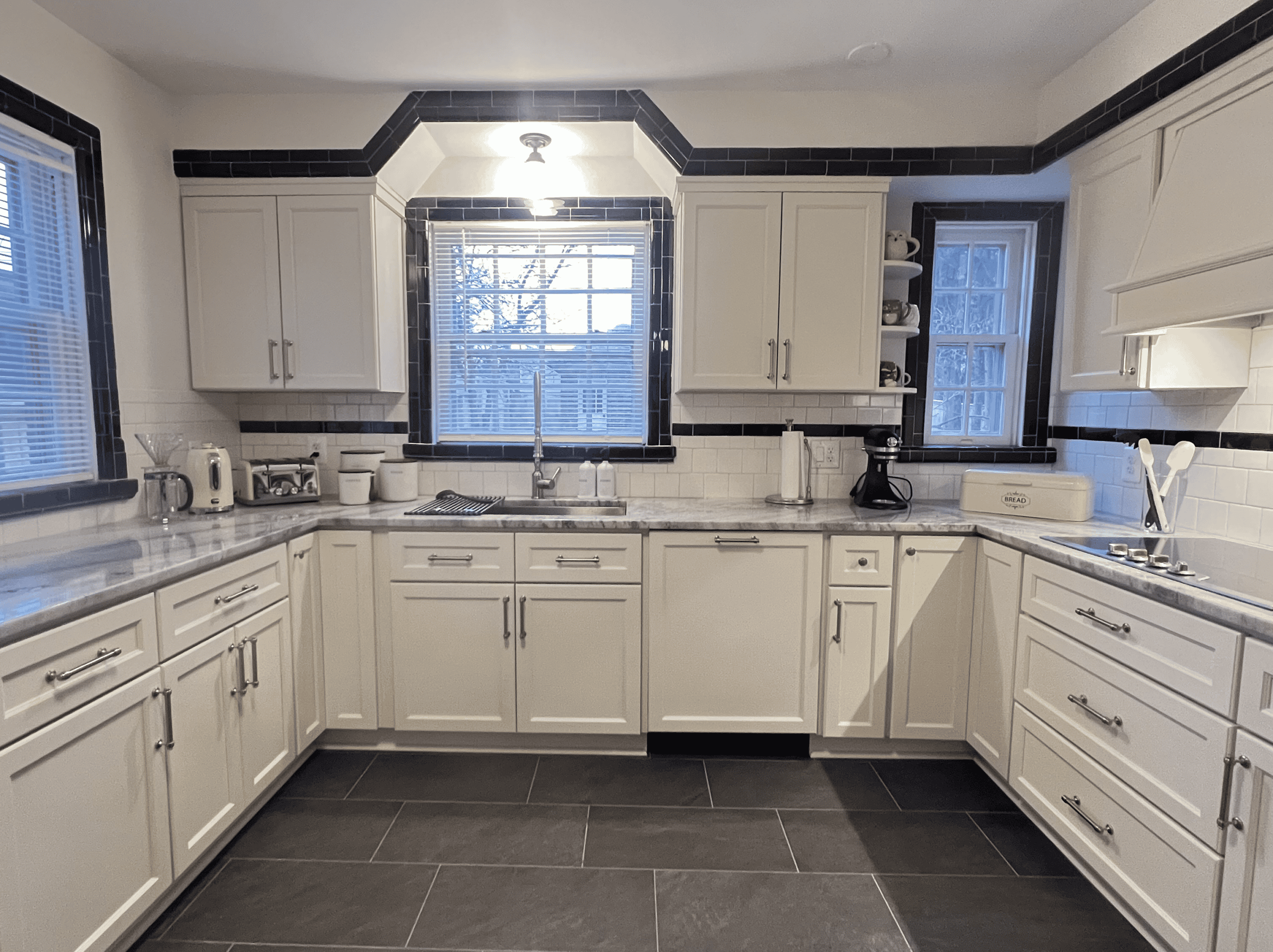 Kitchen remodeling with white cabinets and black accents.