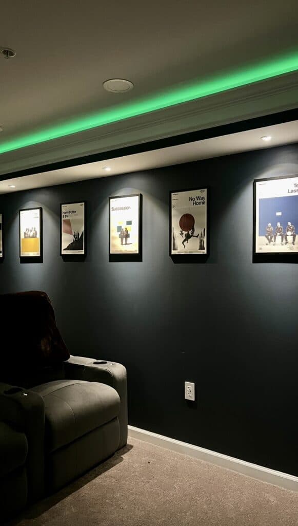 Stylish home theater wall with framed posters and ambient lighting for a cozy entertainment space.