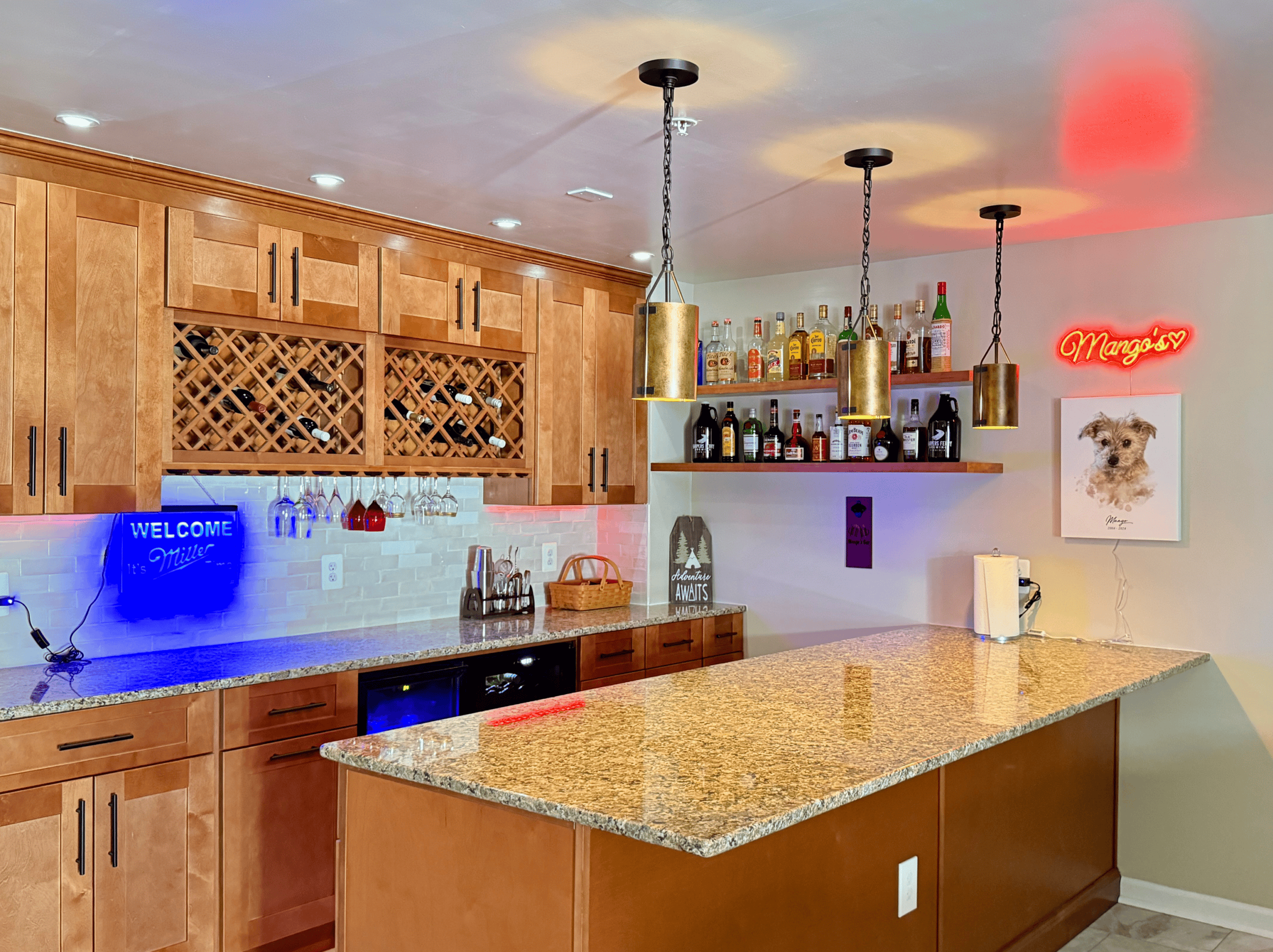 Home bar with wooden cabinets and colorful lighting.