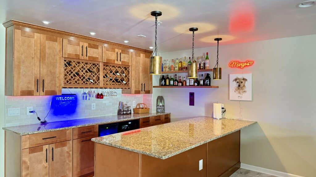 Modern kitchen with wooden cabinets and granite countertops, featuring colorful lighting and a well-.