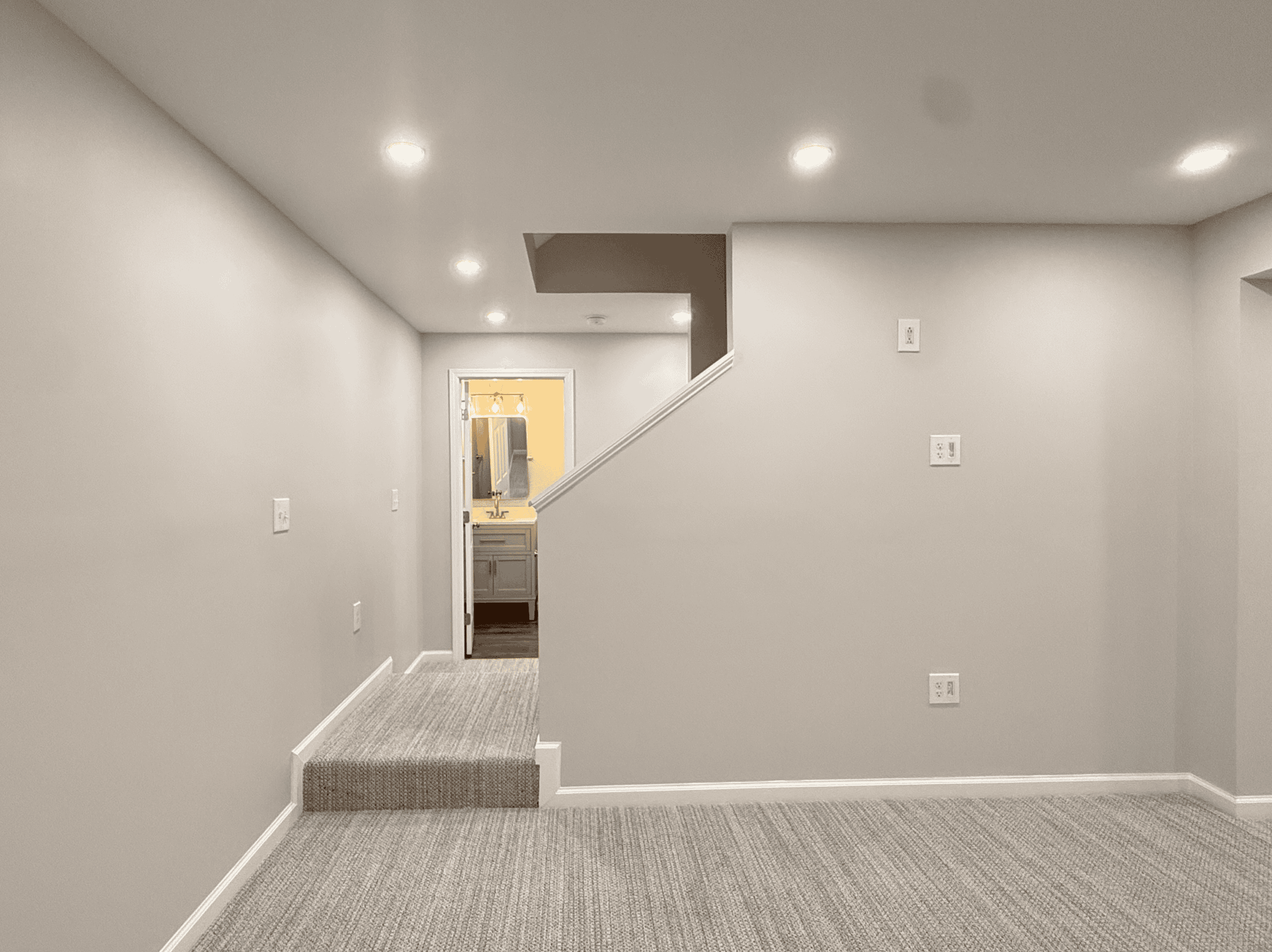 Modern basement renovation with fresh paint and new lighting fixtures.