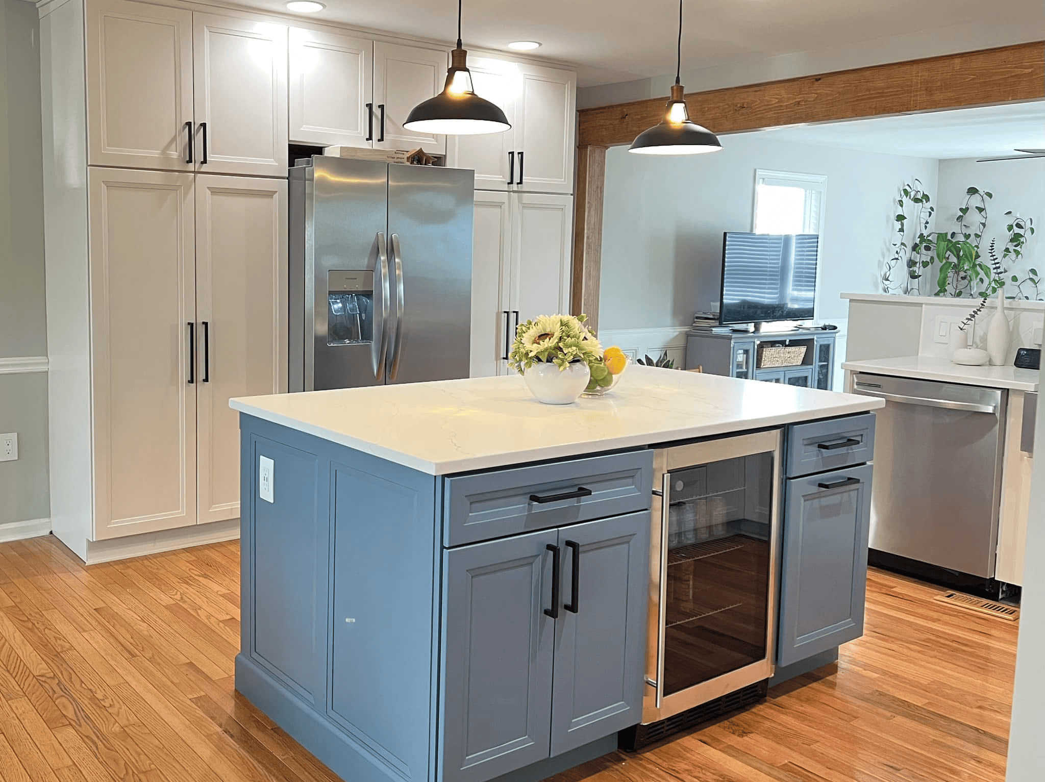 Modern kitchen with blue island and white cabinets.