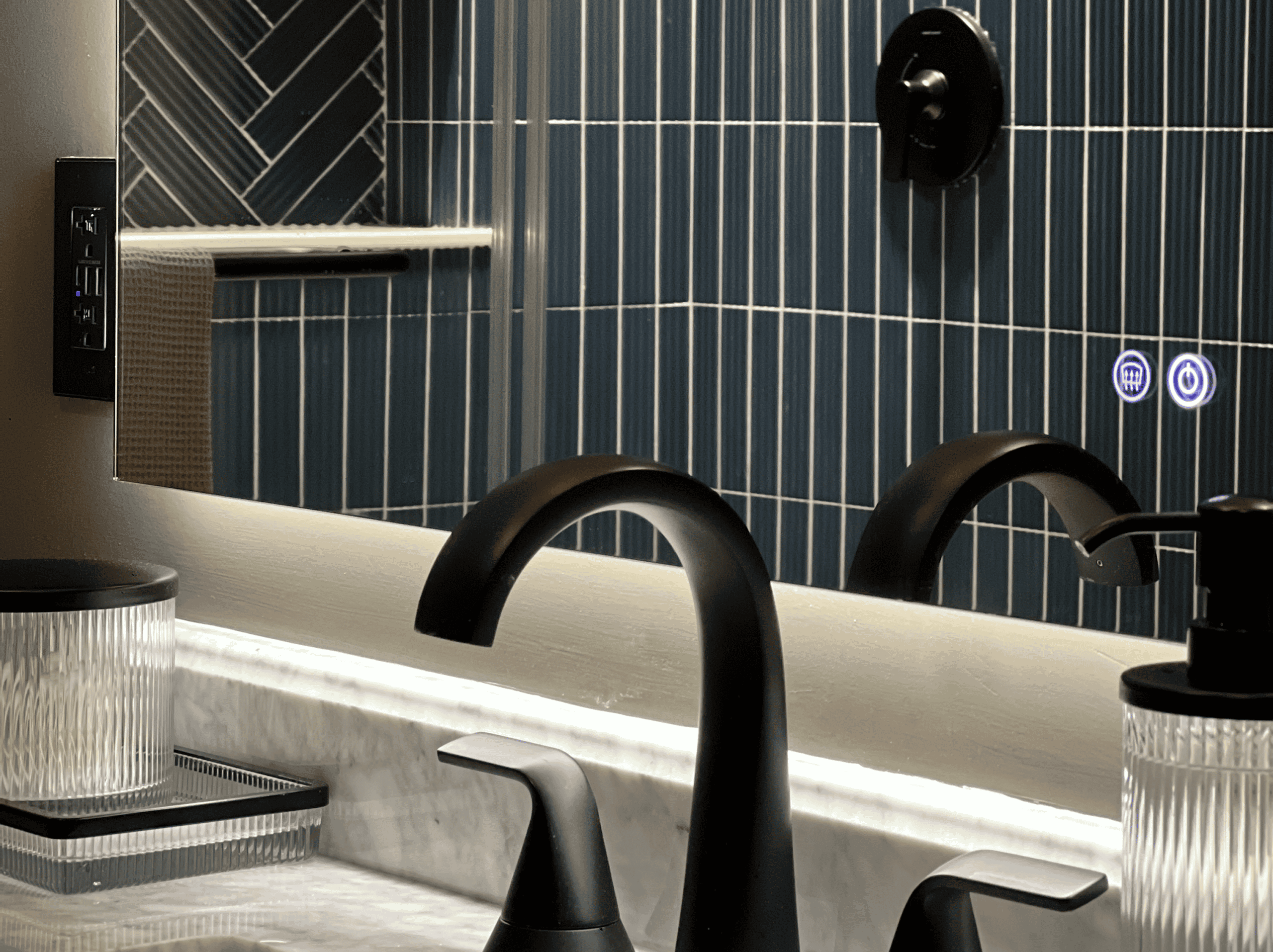 Modern bathroom sink with black fixtures and blue tiled wall.