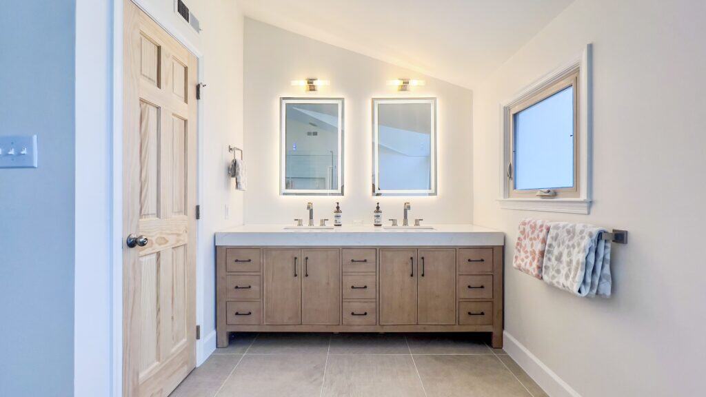 Bright bathroom with double vanity, mirrors, and natural light for a fresh, clean look.