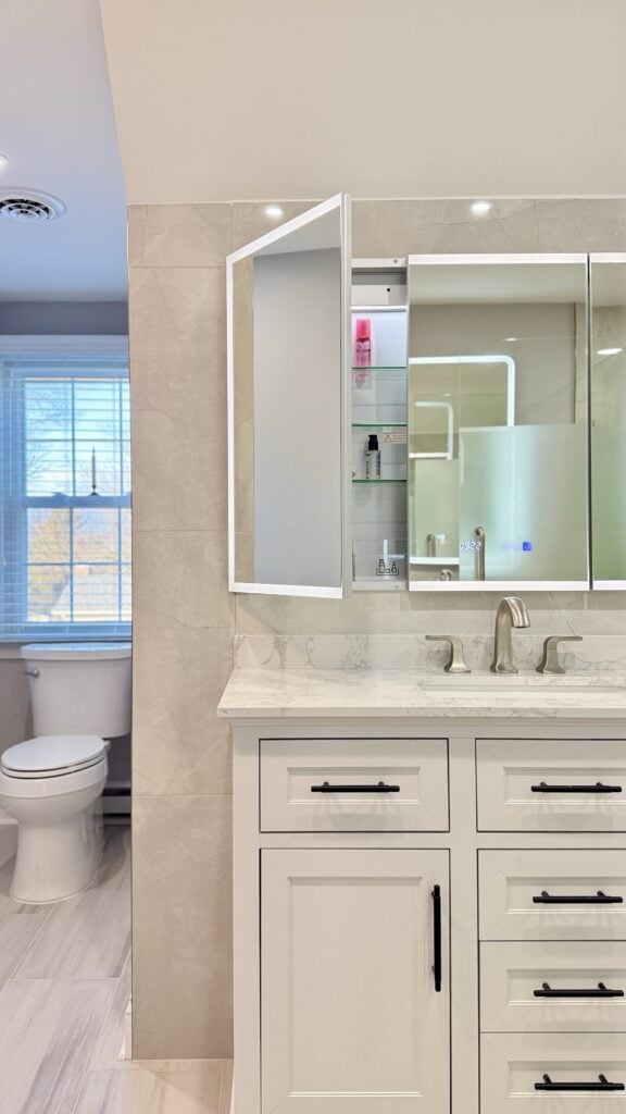 Modern bathroom vanity with mirror and storage shelves in a bright, clean space.