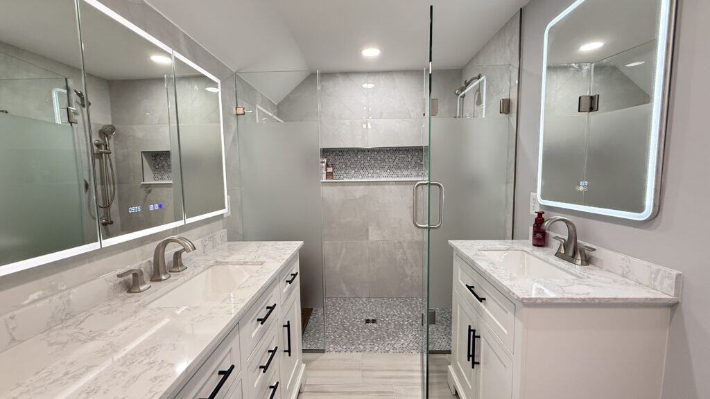 Elegant modern bathroom with dual vanities and glass shower enclosure.