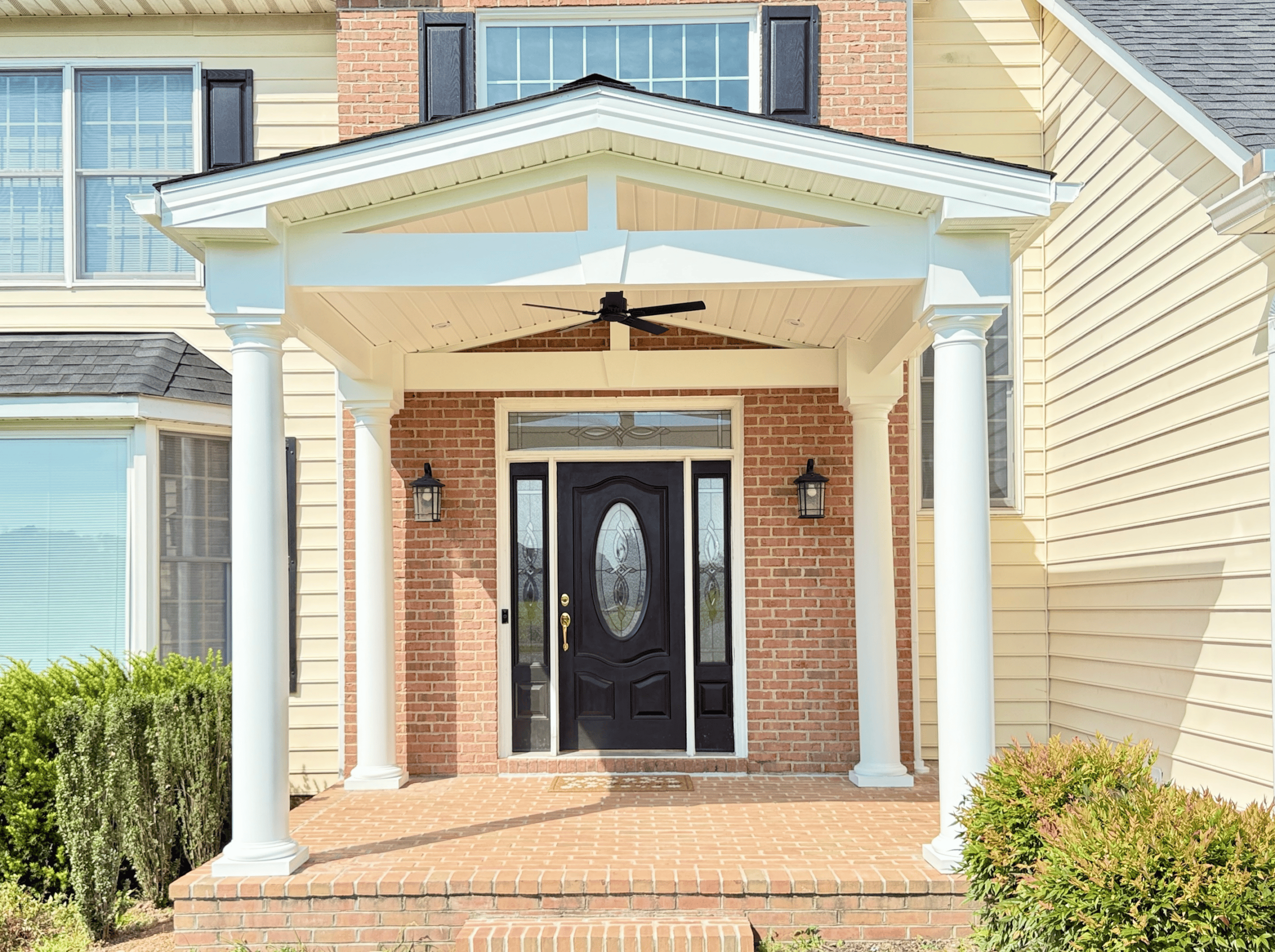 Front porch renovation with columns and brick accents.