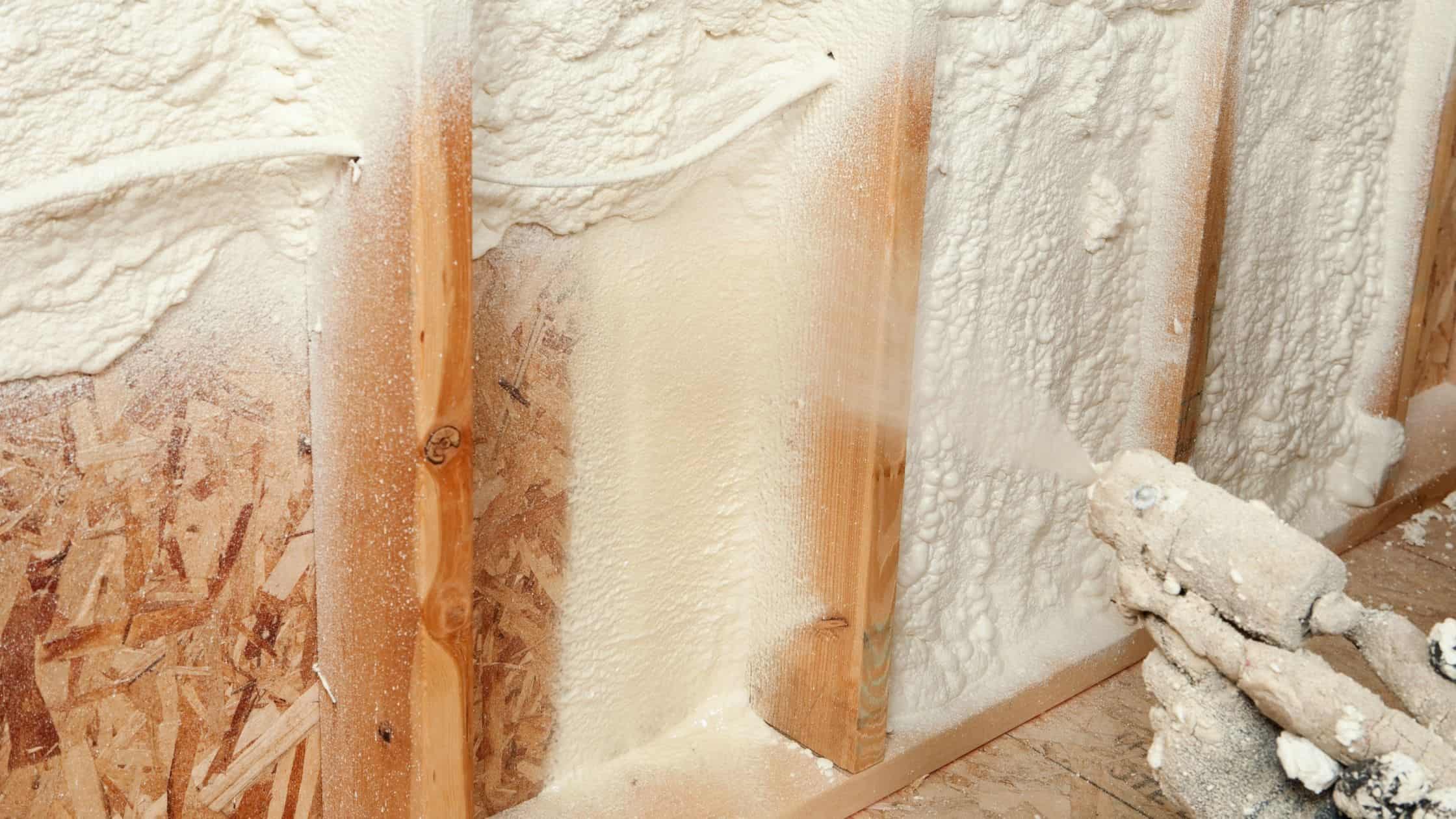 Close-up of wall insulation installation with spray foam in a home renovation project.